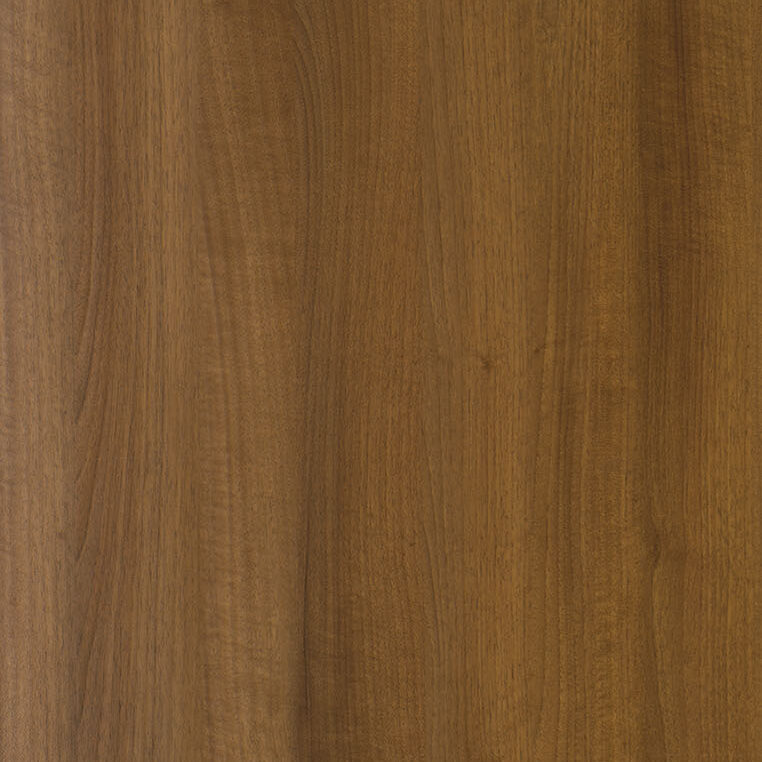 A close-up view of a wooden surface with a smooth and polished finish. The wood grain is visible, displaying natural variations in color and texture, ranging from light to dark brown shades. The surface appears even and without any noticeable imperfections or knots.