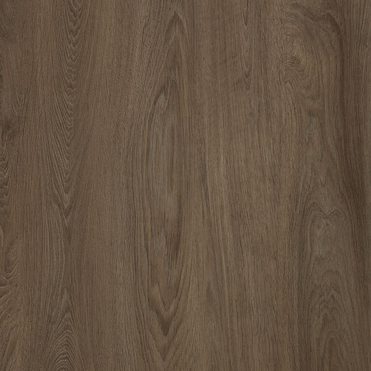 A close-up view of a wooden surface featuring a gray-brown color with natural grain patterns and subtle swirls, displaying the texture and variations in the wood.